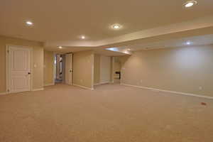 Finished below grade area featuring light carpet and recessed lighting