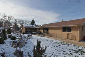 Snow covered house with a patio area and brick siding