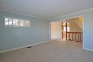Unfurnished room with ornamental molding and carpet floors