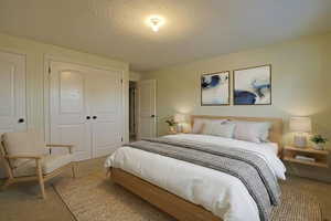 Bedroom featuring carpet floors, a textured ceiling, and a closet