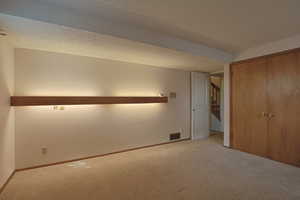 Unfurnished bedroom with carpet floors, a textured ceiling, and a closet