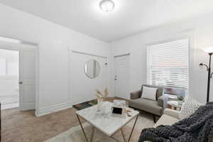 Living area with light colored carpet and baseboards