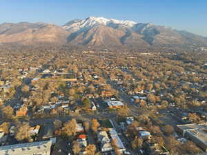 Aerial view of property and surrounding area with mountains and nearby suburban area
