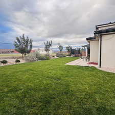 View of yard featuring a trampoline and a patio
