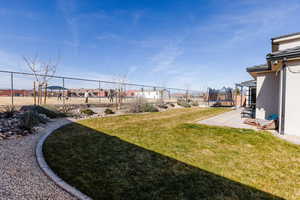 Fenced backyard with a trampoline, a residential view, and a patio area