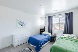 Carpeted bedroom with a textured ceiling and baseboards