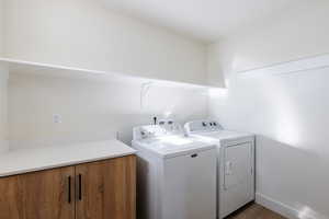 Laundry area with washer and clothes dryer and dark wood-type flooring