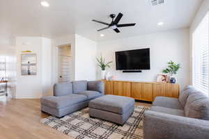 Living area featuring light wood-type flooring, a ceiling fan, a textured ceiling, and recessed lighting
