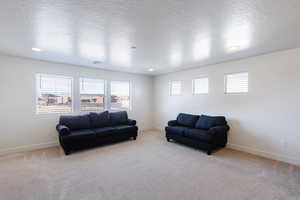 Living room featuring a textured ceiling, light carpet, and recessed lighting