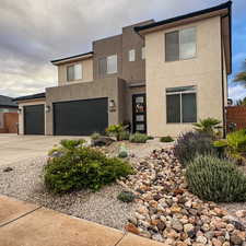 View of front of house featuring stucco siding, driveway, and an attached garage