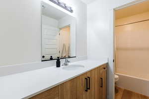 Bathroom featuring vanity, shower / tub combination, and wood finished floors