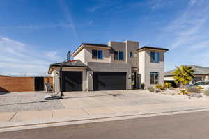 Contemporary home featuring concrete driveway, stucco siding, and an attached garage
