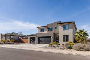 Contemporary house with an attached garage, driveway, and stucco siding