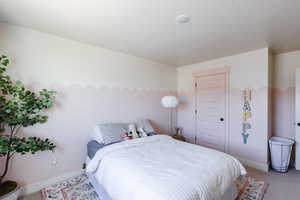 Carpeted bedroom with a closet and a textured ceiling