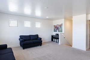 Carpeted living room featuring a textured ceiling and recessed lighting