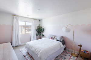 Carpeted bedroom with baseboards and a textured ceiling