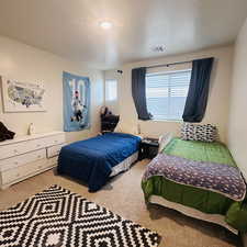 Bedroom with a textured ceiling and carpet