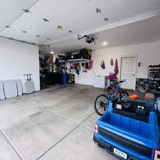 Garage featuring white fridge and water heater