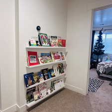 Rec room with baseboards and light carpet