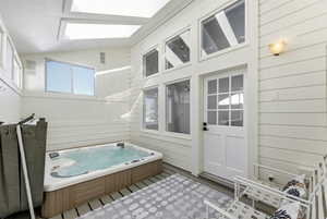 Exterior space with a hot tub and lofted ceiling