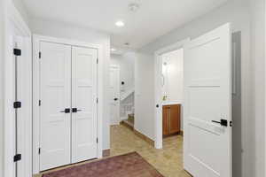 Hall with stairway, recessed lighting, and stone finish flooring