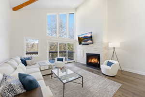 Living area with a high ceiling, a fireplace with flush hearth, and wood finished floors