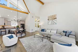 Living area featuring high vaulted ceiling, light wood-style floors, a chandelier, recessed lighting, and beamed ceiling