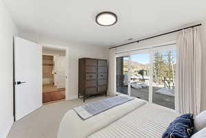 Carpeted bedroom with access to exterior, ensuite bath, and a mountain view