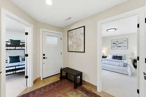 Carpeted foyer entrance featuring baseboards