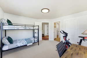 Carpeted bedroom featuring a closet and baseboards
