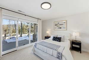 Bedroom with access to outside and light colored carpet