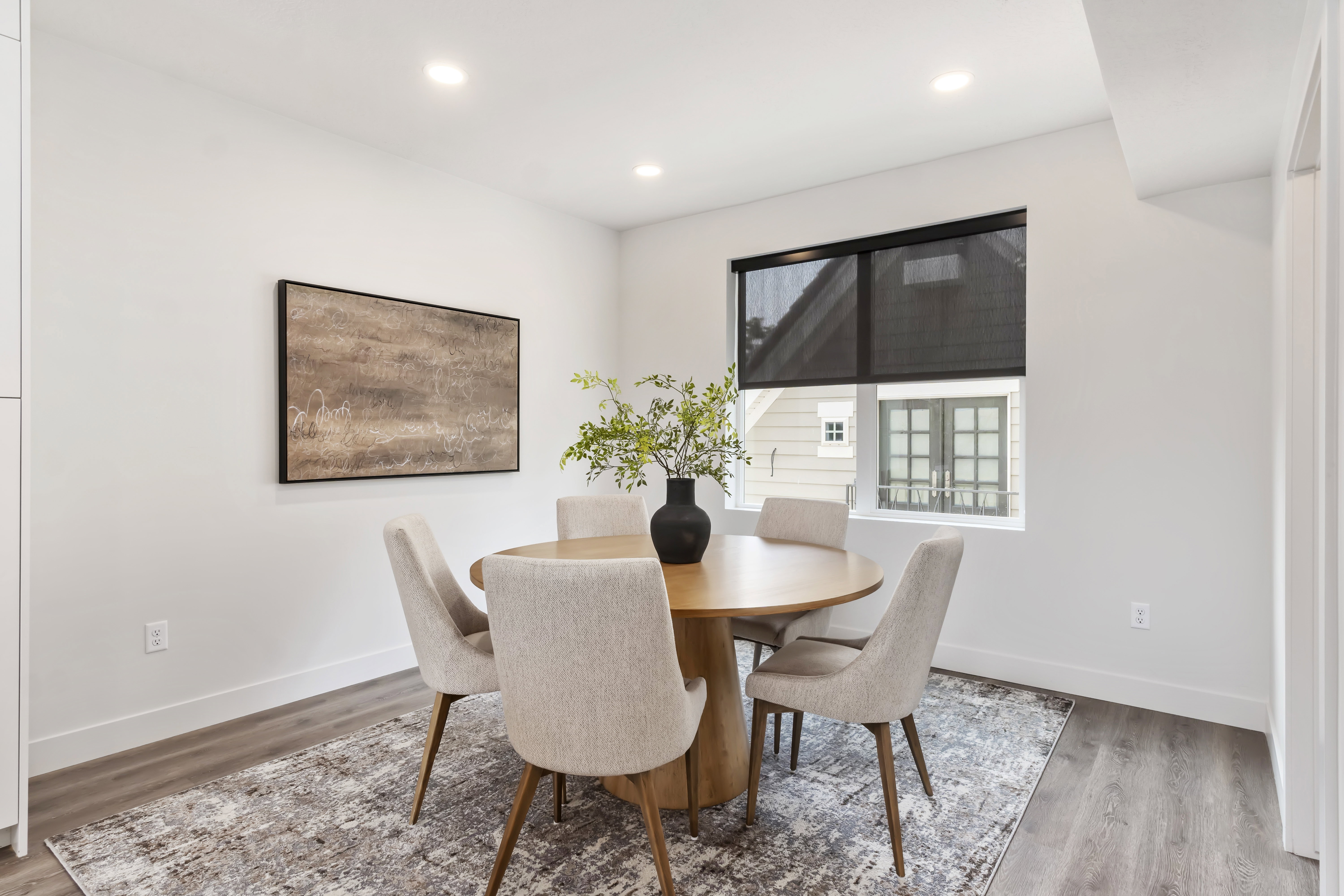 Dining space with light wood finished floors and recessed lighting. Model Home