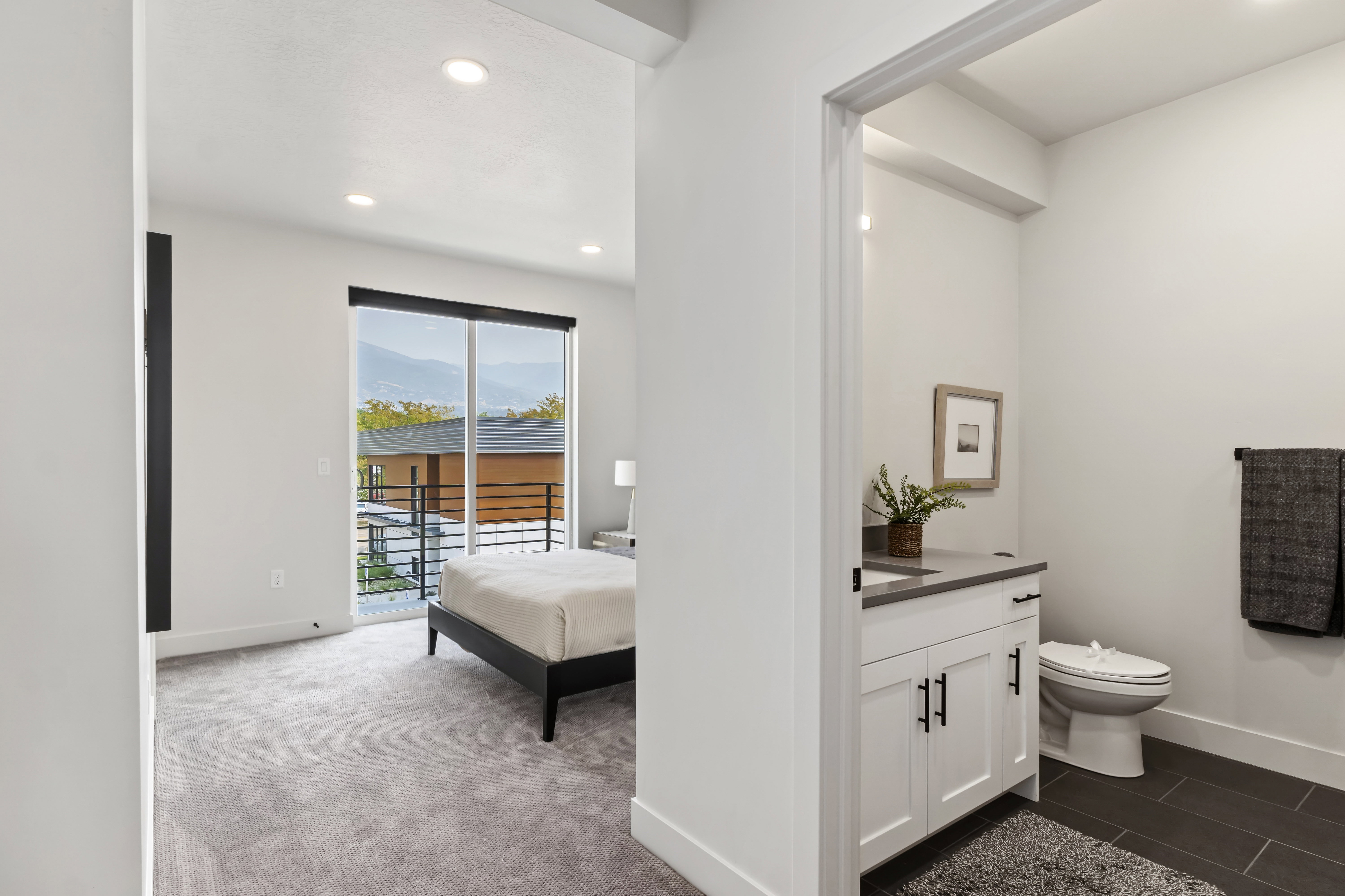 Half bath with vanity, recessed lighting, dark colored carpet, and an ensuite bath. Model Home