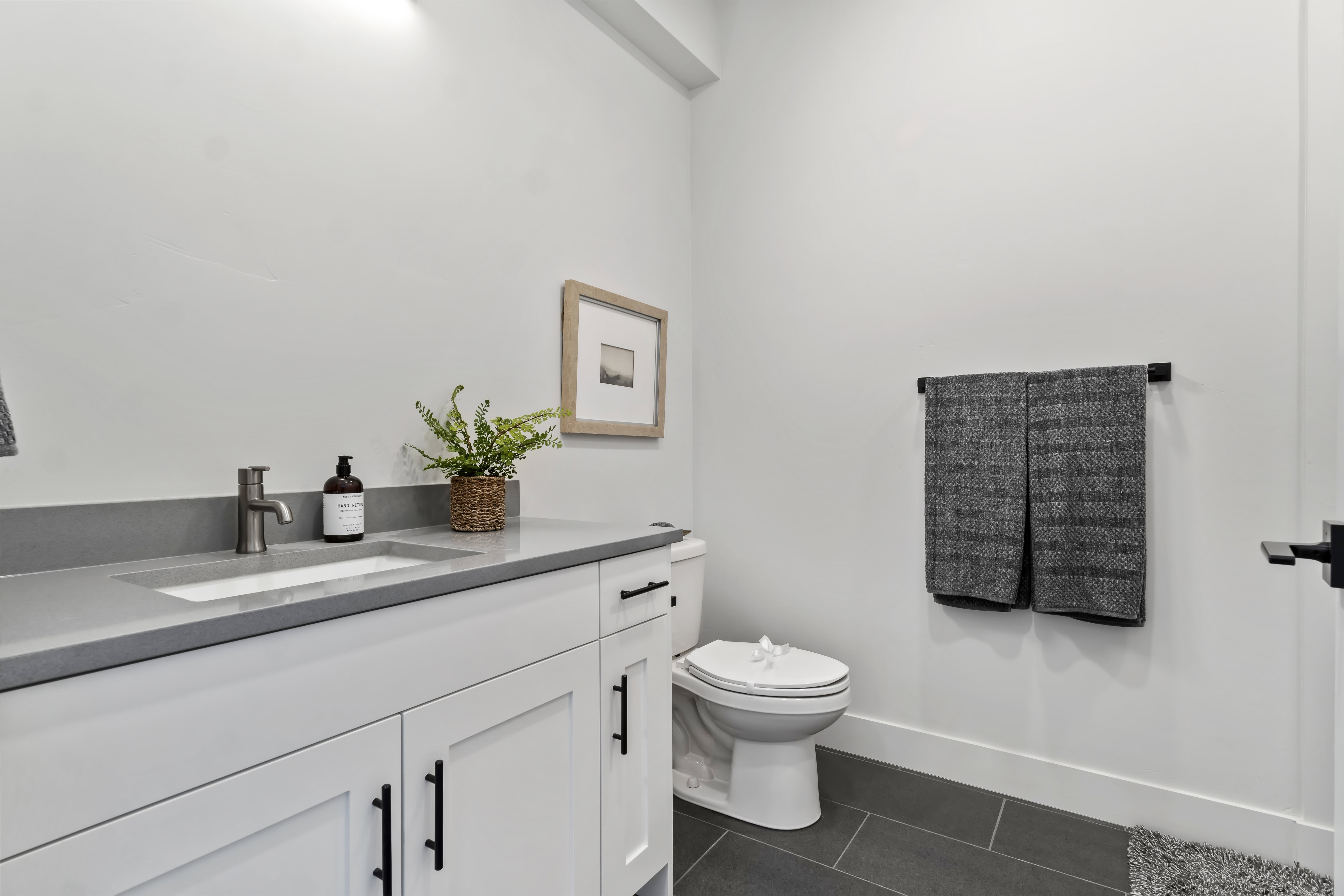 Bathroom with vanity and dark tile patterned flooring Model Home