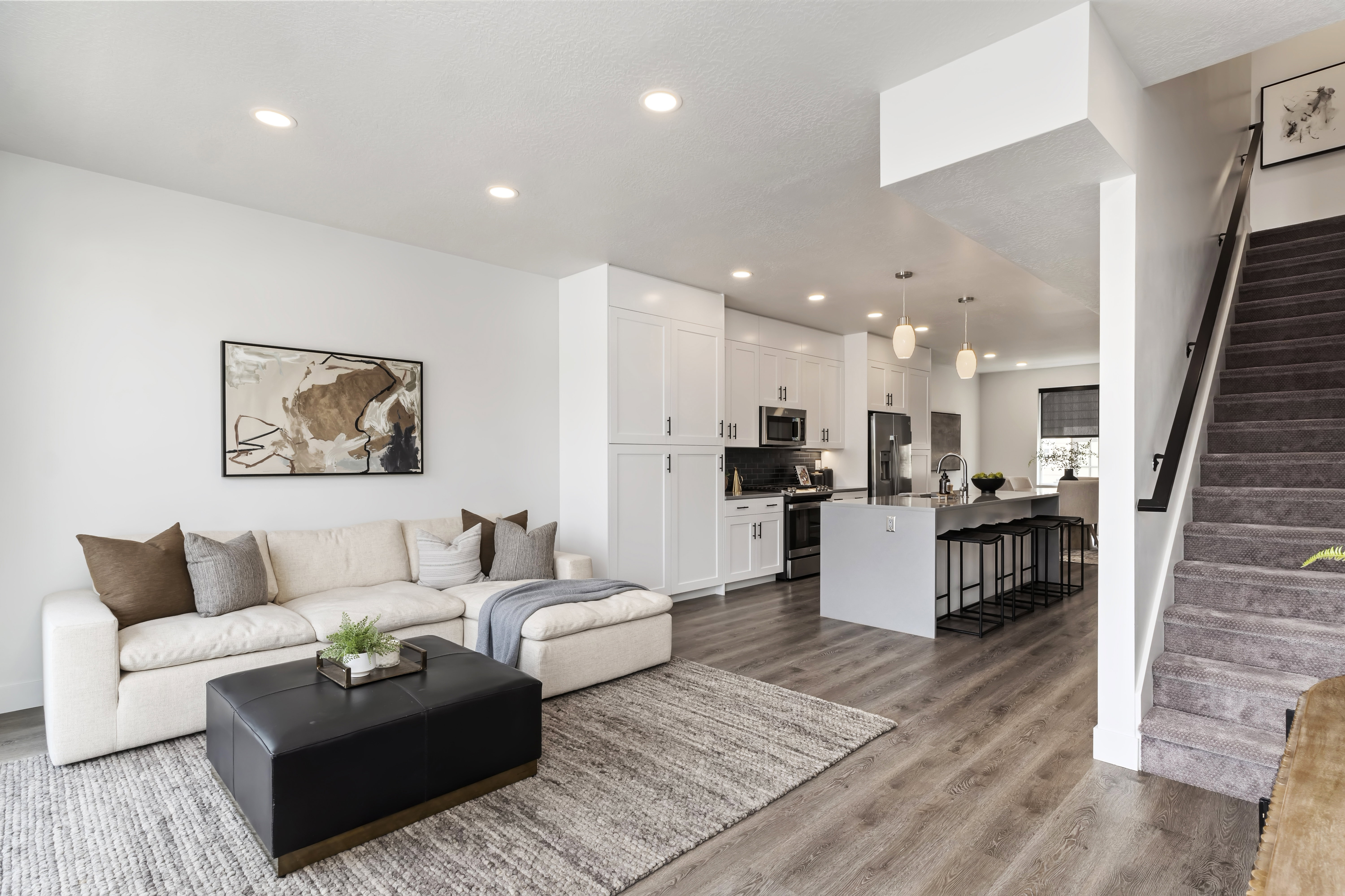 Living area with stairway, light wood-type flooring, and recessed lighting. Model Home