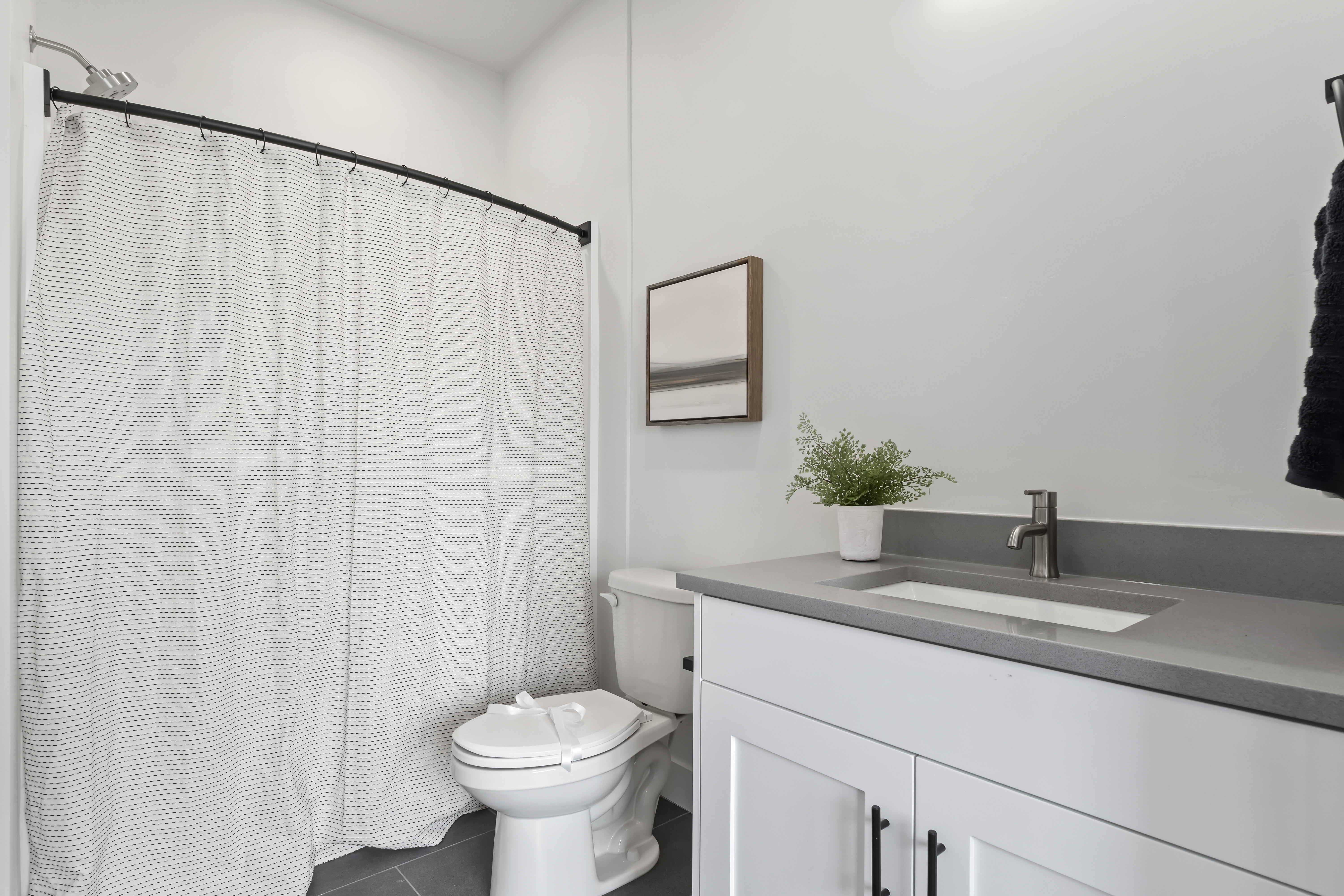 Bathroom featuring vanity, curtained shower, and dark tile patterned floors
