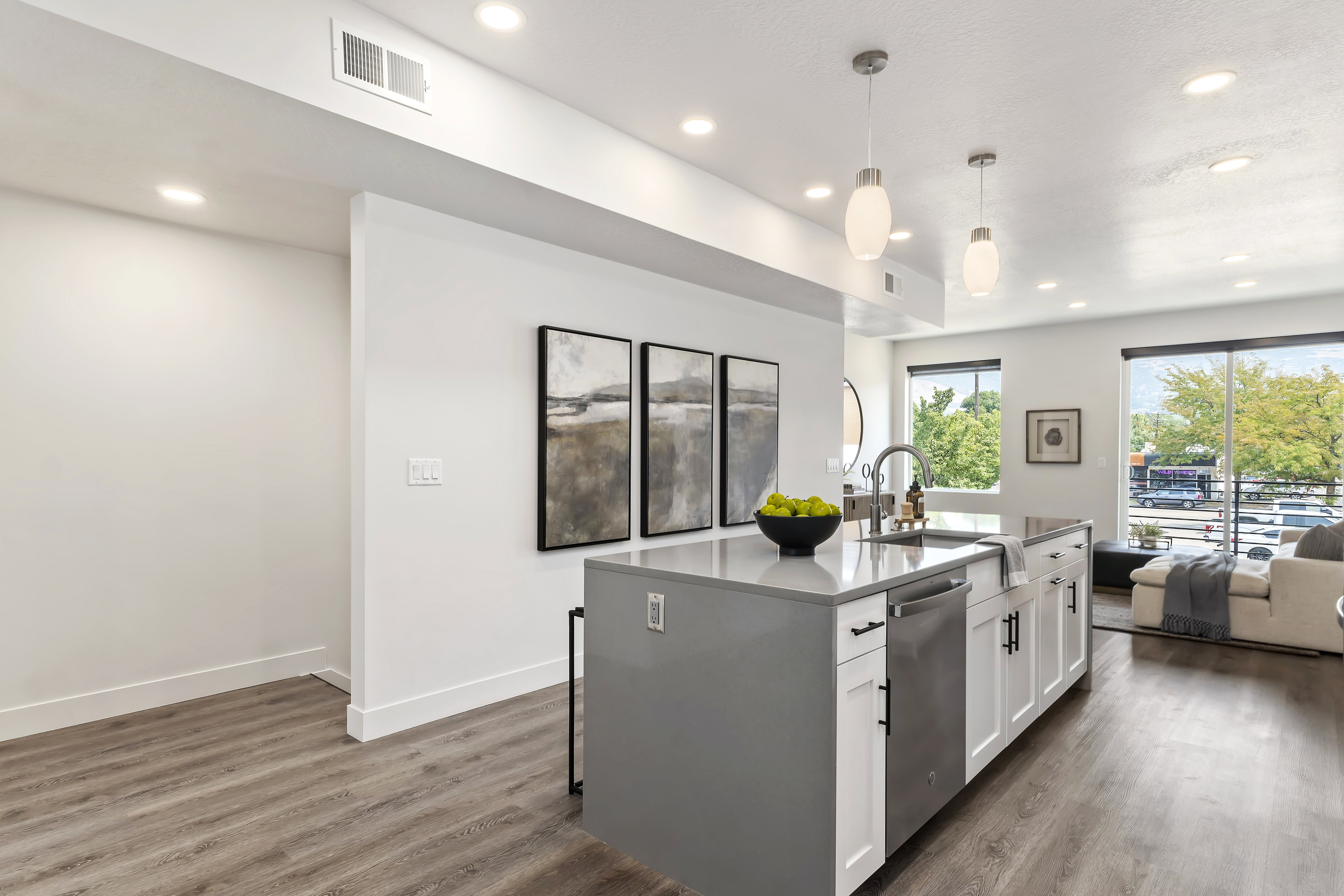 Kitchen featuring pendant lighting, dark wood-style floors, white cabinetry, open floor plan, and recessed lighting. Model Home