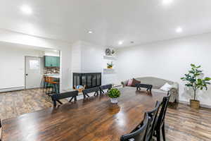 Dining area featuring dark wood-style flooring, a large fireplace, and recessed lighting