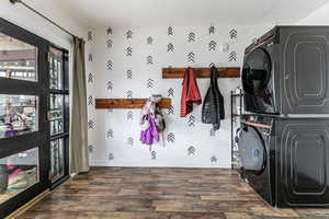 Laundry room with stacked washer / drying machine and dark wood-style floors