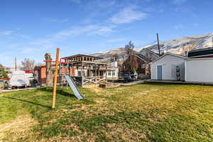 Back of house featuring a yard and a mountain view