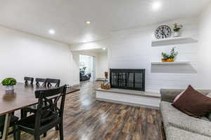 Dining room with a fireplace, dark wood-style flooring, and recessed lighting