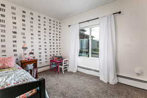 Carpeted bedroom with a baseboard radiator