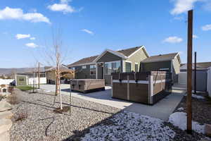 Rear view of house featuring endless pools, hot tub and a storage unit