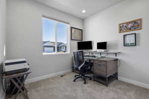 Office with light colored carpet and recessed lighting
