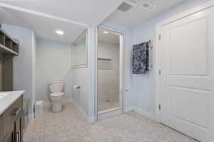 Full bath featuring vanity, tiled shower, and recessed lighting