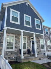 View of front of home featuring a porch and stone siding
