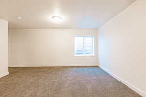 Additional bedroom or family room featuring a textured ceiling and baseboards