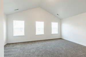 Primary bedroom with vaulted ceiling and lots of natural light