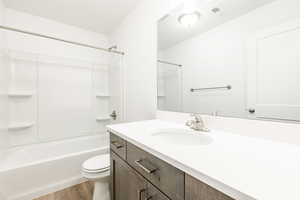 Full bathroom with shower / tub combination, vanity, and light wood finished floors
