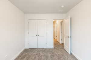 Unfurnished bedroom featuring carpet, a closet, and a textured ceiling